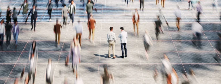 Two business men standing still in a crowd of fast-paced people